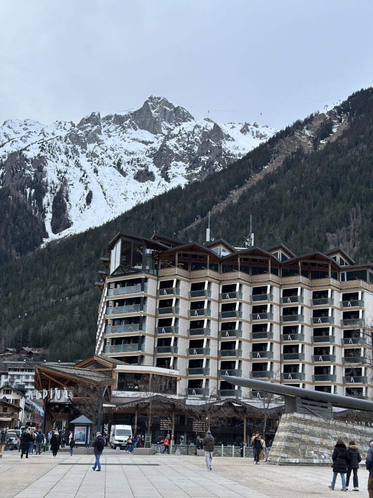 View of the French Alps (and Alpina Hotel) from an open plaza along Av. du Mont Blanc in Chamonix, France. 